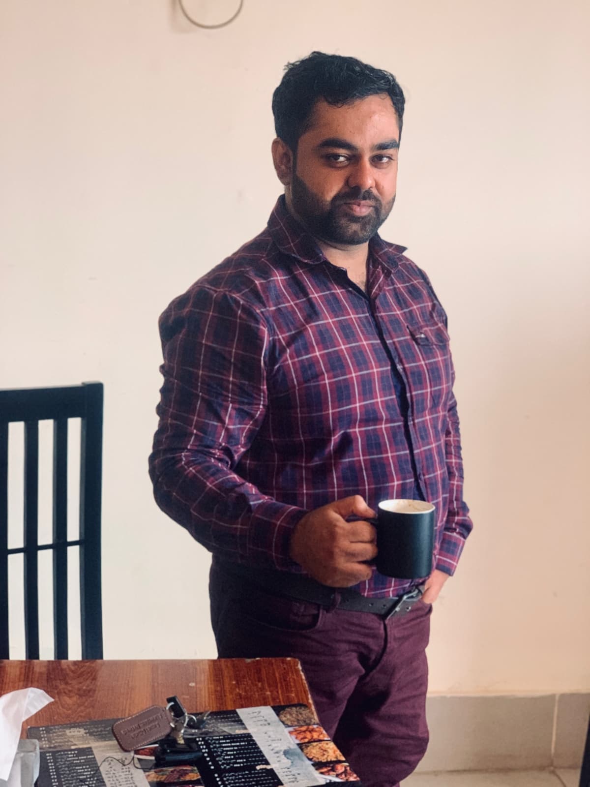 Mohsin Ali standing with a coffee mug